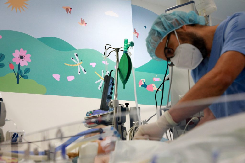 chirurgo assiste bambino in terapia intensiva